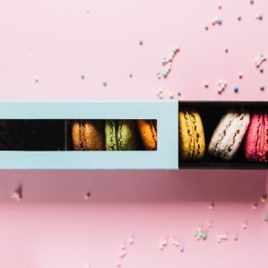 elevated-view-colorful-macaroons-box-pink-background (1)